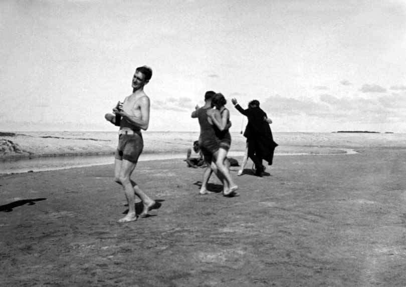 Two couples dance on the beach in the early morning to the sounds of a ukulele at a Hawaiian Sunrise Soiree, 1920.