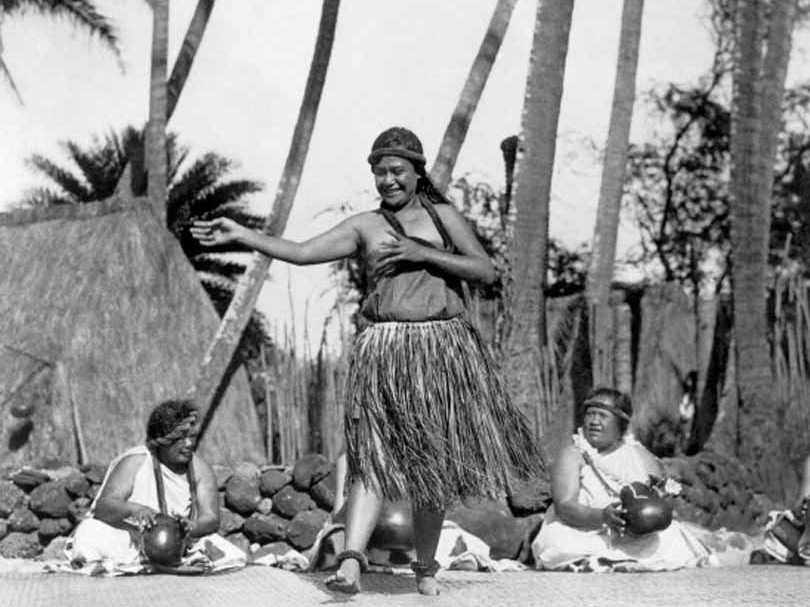 A native Hawaiian dancer performs while other women keep rhythm with gourds, 1924.