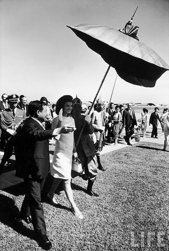 Jackie Kennedy arriving in Pnompenh and being escorted by Prince Norodom Sihanouk and the royal umbrella bearer. 1967