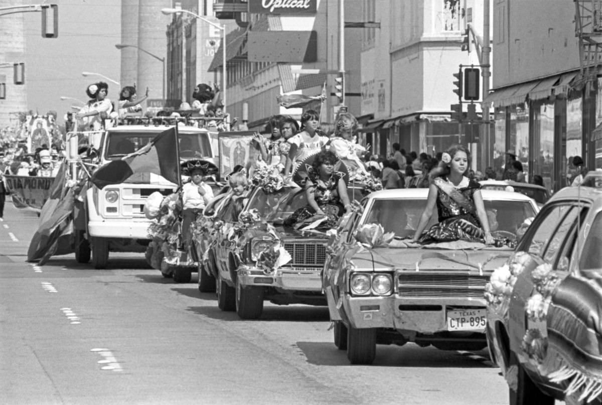 Two candidates for the Mexican Independence Day Fiesta Queen wave from cars in Fort Worth, Texas, 1977.