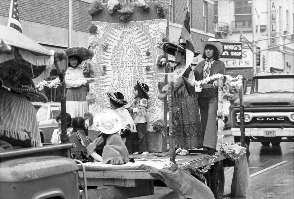A parade float with people in traditional Mexican attire and imagery of Our Lady of Guadalupe at the Mexican Independence Day parade in Fort Worth, Texas, 1974.