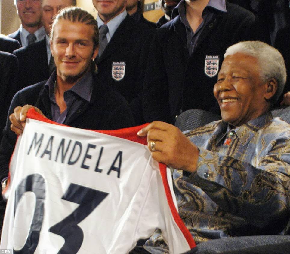 Former President Nelson Mandela receives an England team jersey with "Mandela" on the back from captain David Beckham in Johannesburg in 2003.