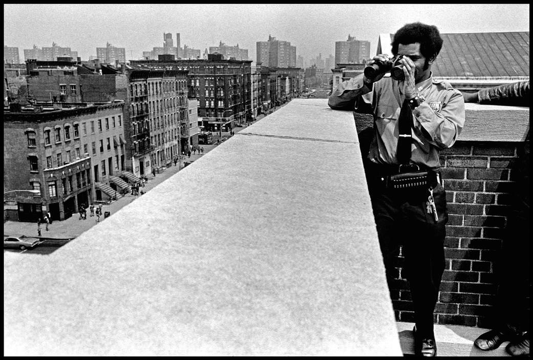 A police officer on a roof oversees drug dealers trying to sell drugs to schoolchildren, 1972.