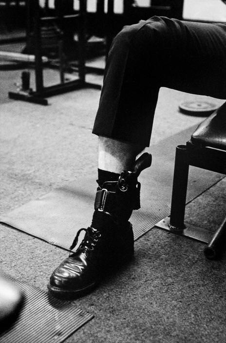 The officer shoots a gun with an ankle before school in the gym, 1979.