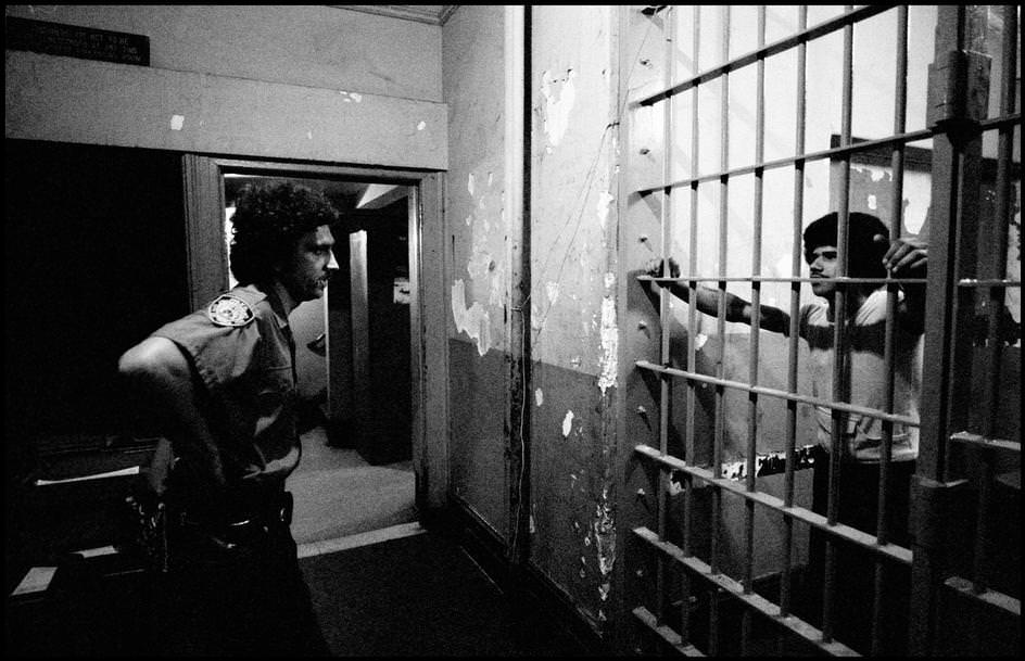 The detainee and the officer looked at each other in a police station, 1978.