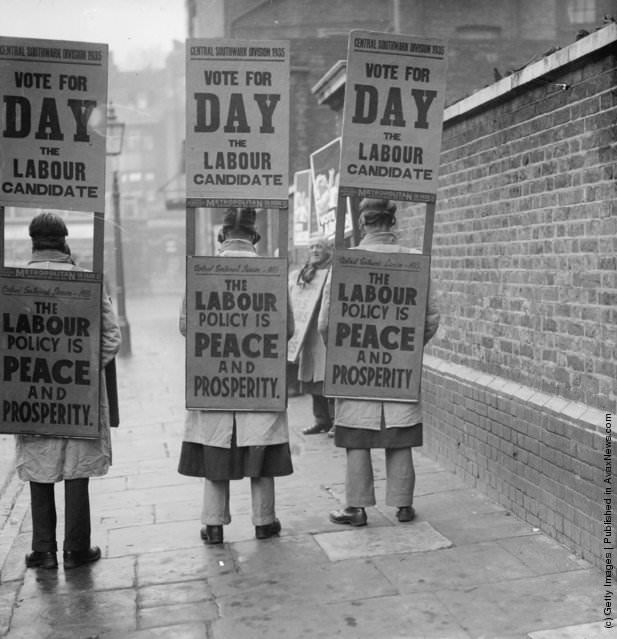 Labour supporters electioneering in gas masks, promoting "Vote Labour," 1935.