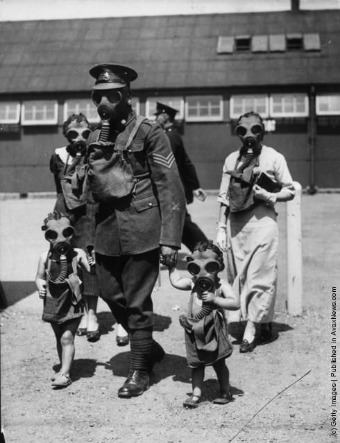 A soldier escorting young visitors to gas chambers at Kingston Barracks, Surrey, 1935.