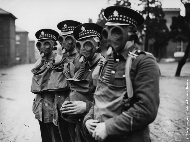 Scots Guards trying on gas masks before sailing to China, 1927.