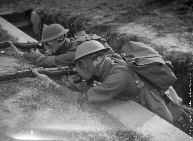 Royal Marine recruits practicing trench warfare in gas masks, 1933.