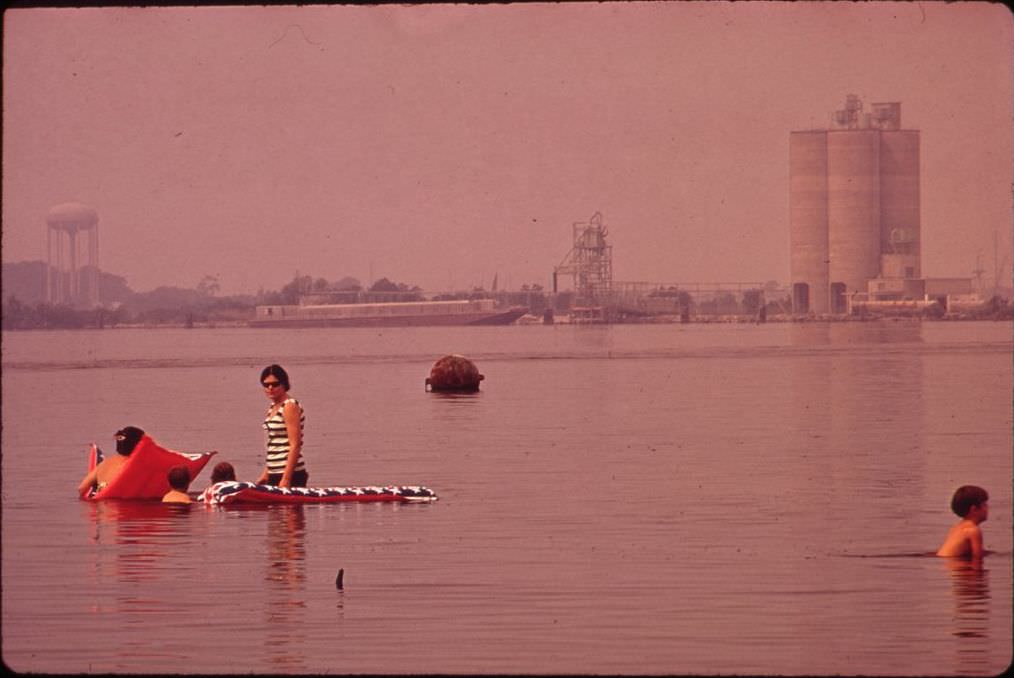 Swimming in polluted Lake Charles, with the Olin-Mathieson Plant in the background, 1972.