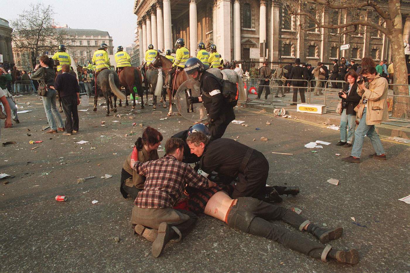 An injured protester during rioting after an anti-poll tax demonstration in Trafalgar Square, 1990.