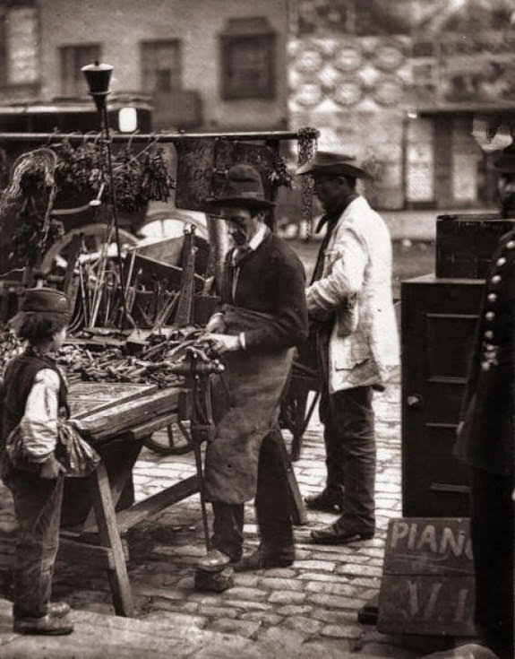 A street locksmith mending locks at his stall, 1877.