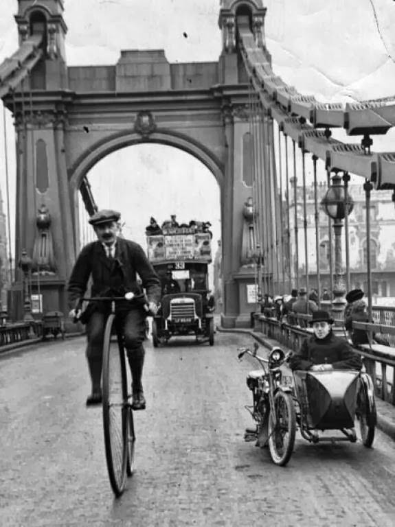 A cyclist on a penny farthing over Hammersmith Bridge, London, 1800s.