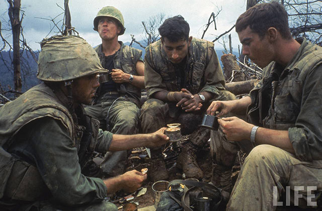 US Marines eating rations during a lull in the fighting near the DMZ during the Vietnam War.