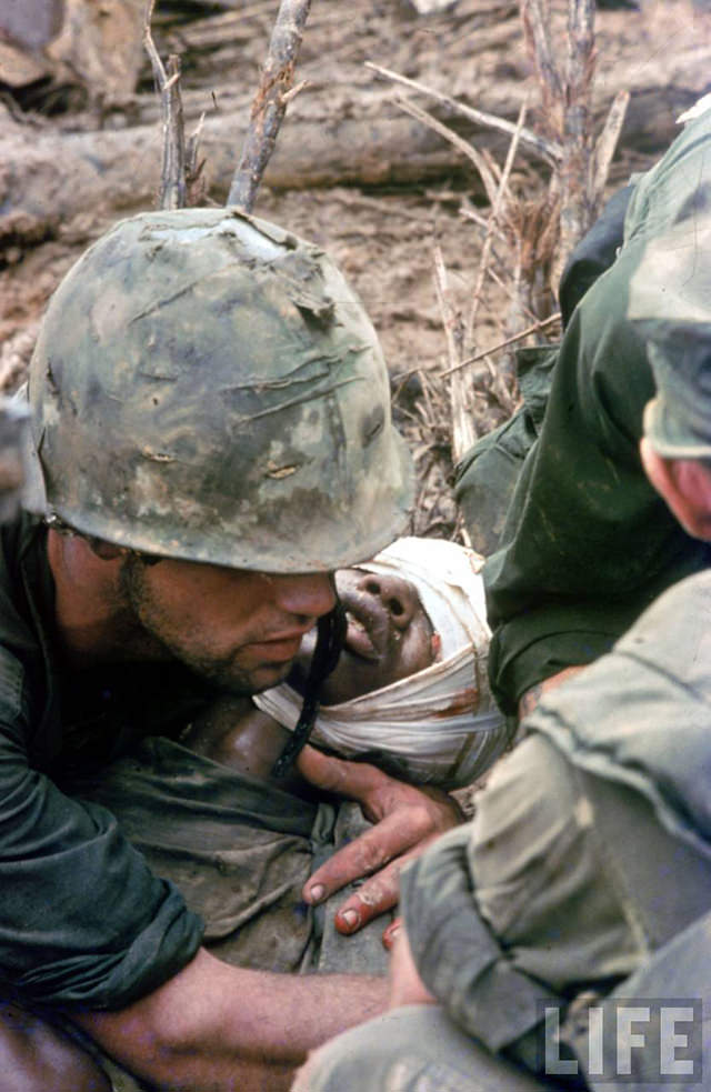 American soldiers tending wounded comrade while awaiting evacuation just south of the DMZ during the Vietnam War.