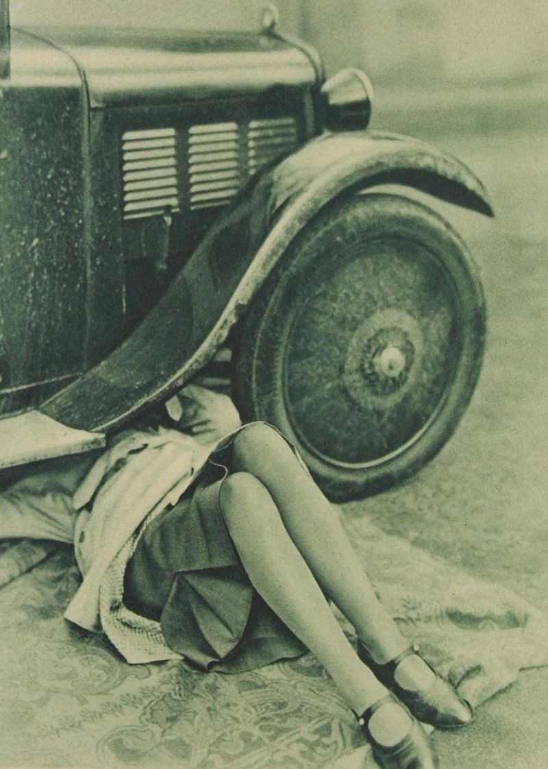 Flapper under a car, 1920s.