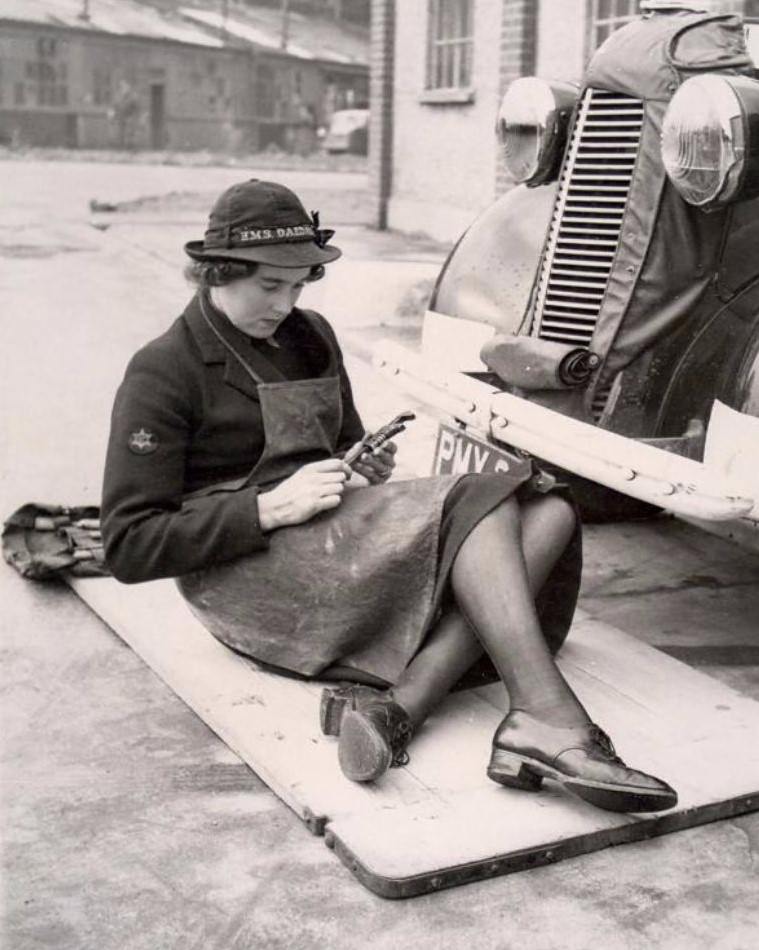 A 'Wren' works as a mechanic, her hat reads 'H.M.S. Daedalus', 1940s.