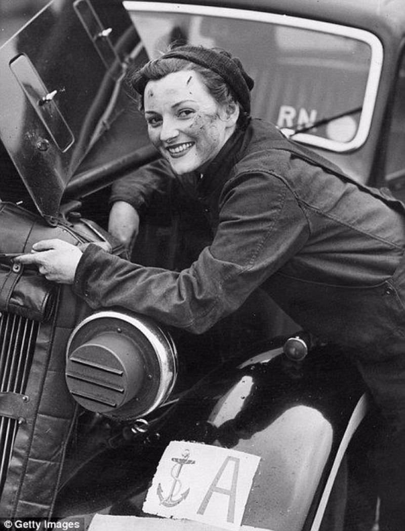 A motor transport driver from the Women's Royal Navy Service, repairing the engine of her car, 1943.