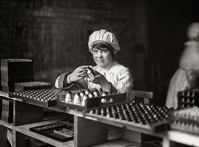A woman assembly line worker at a munitions factory during World War I, 1917.