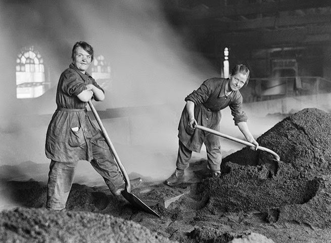 Women workers feeding a charcoal kiln at a Scottish sugar refinery during World War I.