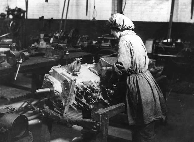 A woman working on an engine in an engineering shop, 1915.