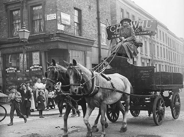 A woman driving a wagon and horses in north London during World War I, 1916.