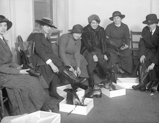 Women police at a munitions works trying on new boots, 1917.