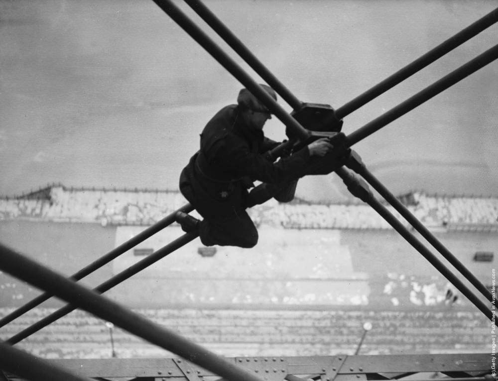 A riveter carrying out repairs to the main girders of the Blackpool Tower, 1937.