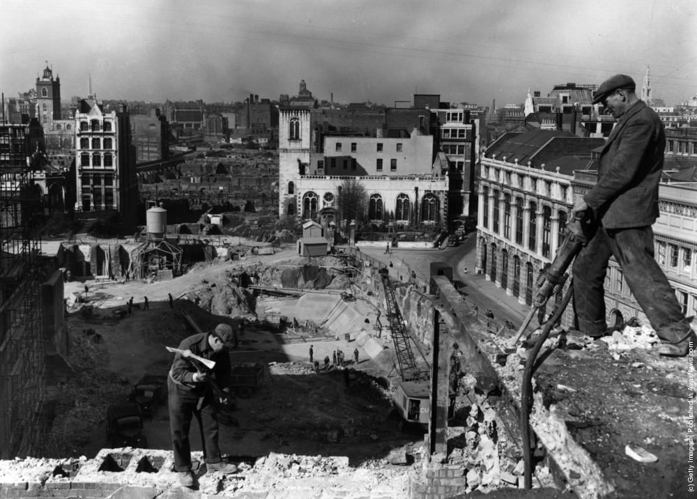 Workmen demolishing the walls of a bomb wrecked building, while work has started on the foundations for a new office block, 1954.