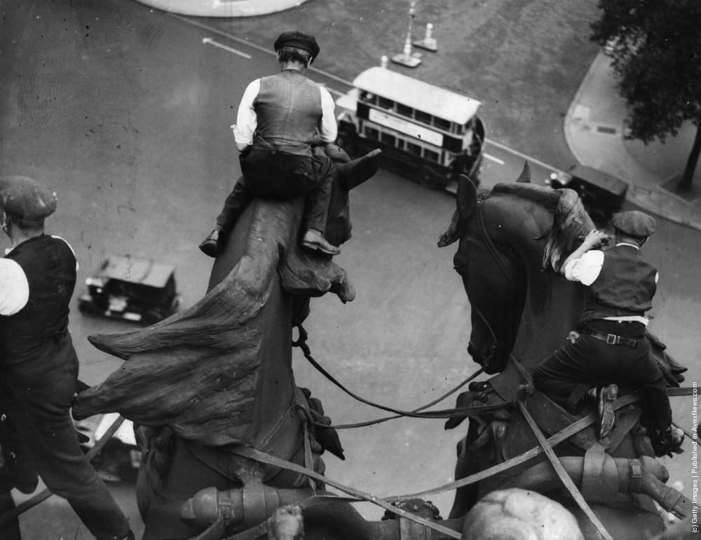 Workmen cleaning the horses heads of the quadriga statue on the Wellington Memorial at London's Hyde Park Corner, 1958.