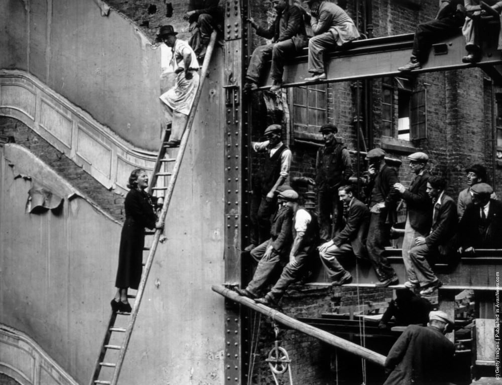 English comedienne and singer Gracie Fields singing to workmen at London's Prince of Wales Theatre after laying its foundation stone, 1937.