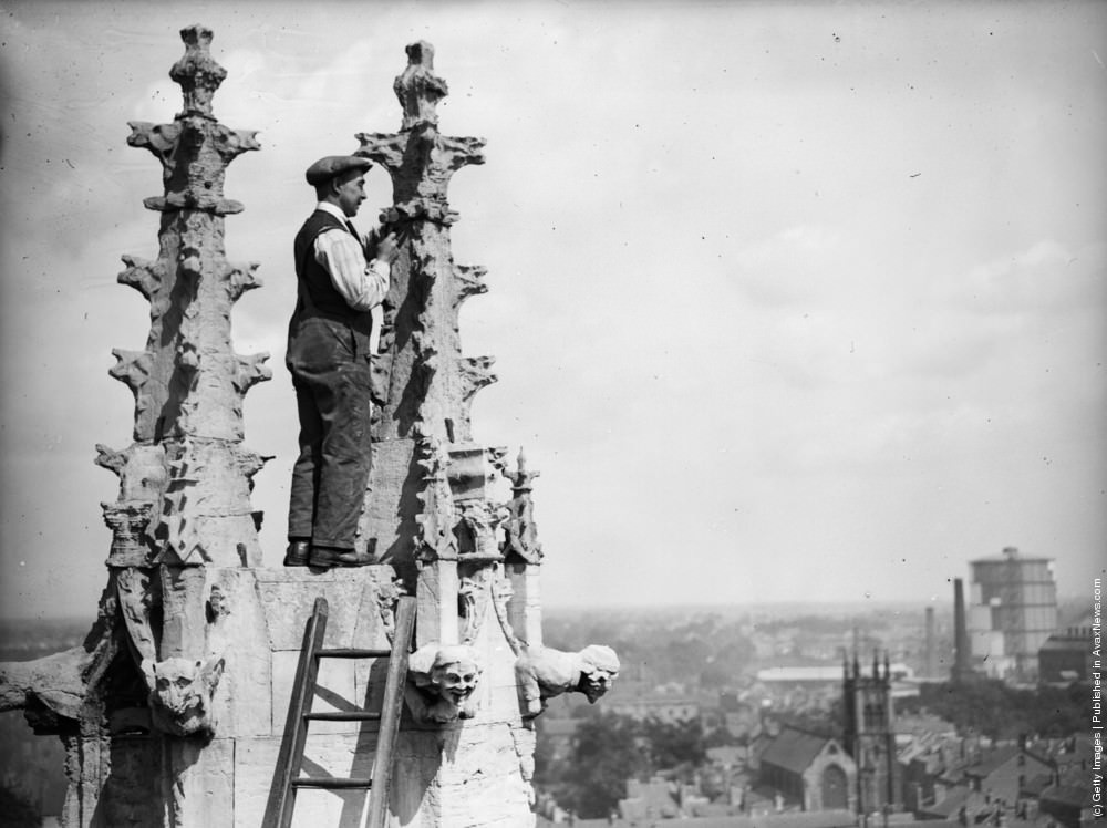 A workman renovating the Gothic spires of the cathedral of St Peters in York Minster, 1931.