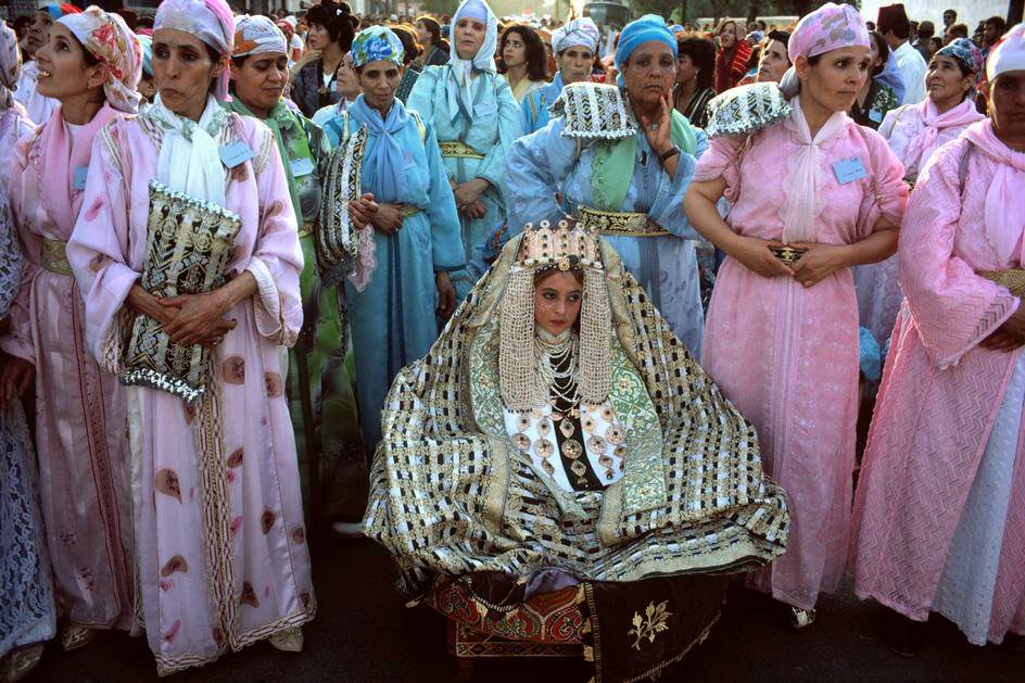 Bride accompanied by 'naggafat', ladies who carry her shoulder level on a platter, 1984.