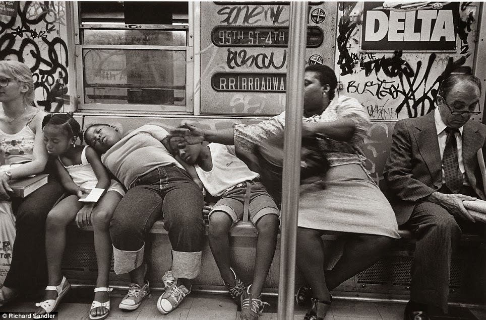 Three sleeping children slump against their carer as another woman tries to protect them, 1982.