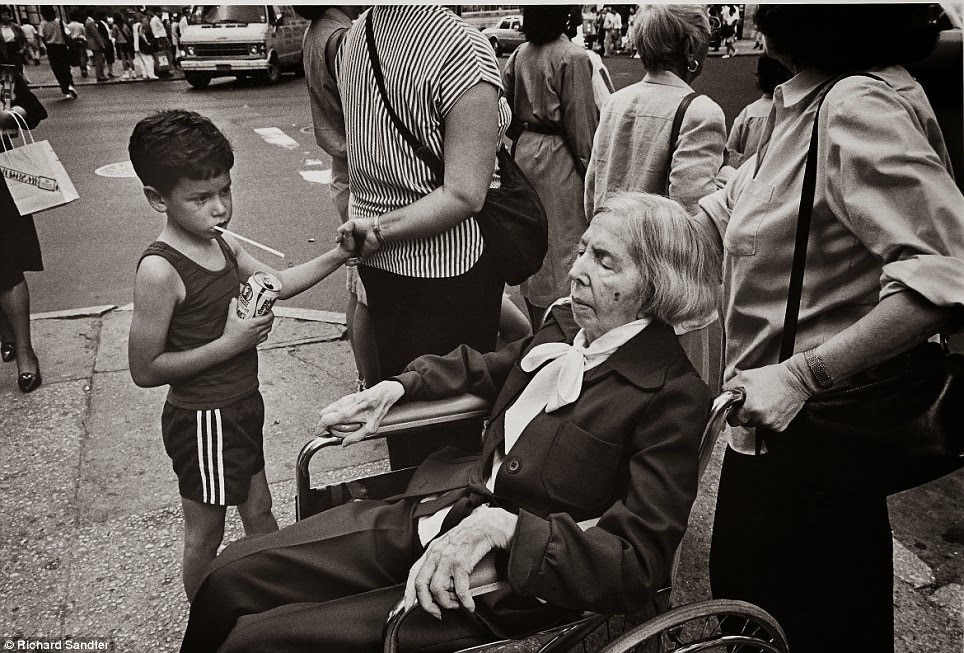 A little boy stares at an elderly woman on Fifth Avenue.