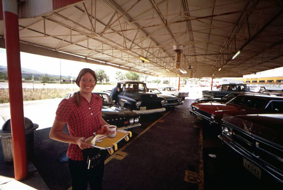 A waitress at the local A&W Drive-In is saving her earnings for out-of-town schooling, 1973.