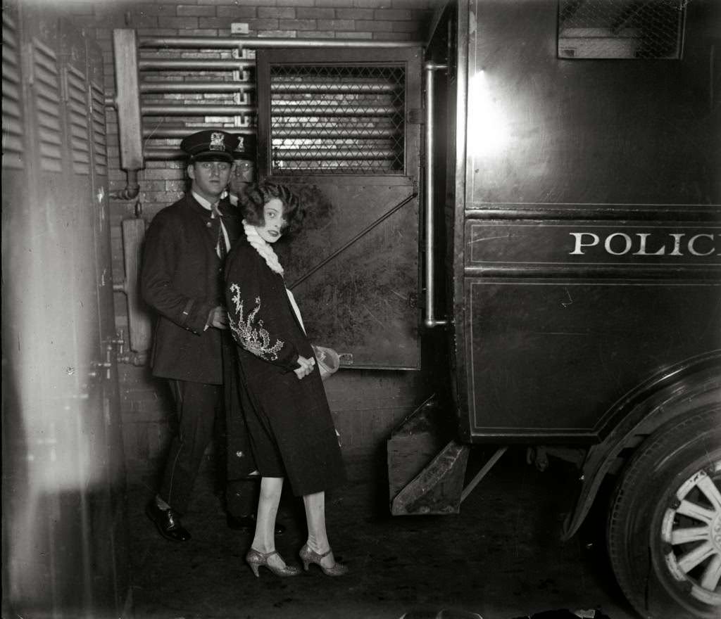 Gertrude 'Billie' Murphy, 22, is brought in for questioning in the murder case of Michael Stopec, who was shot and killed in an apartment hotel, circa July 1927. Murphy had been friends of the married Stopec and his suspected killer Henry Guardino, 31. It is said that Stopec and Guardino were 'bitter rivals for the favor of Billie' and that Murphy had tired of Guardino and was going to stay with Stopec. Murphy was also married to a man in the Joliet penitentiary.