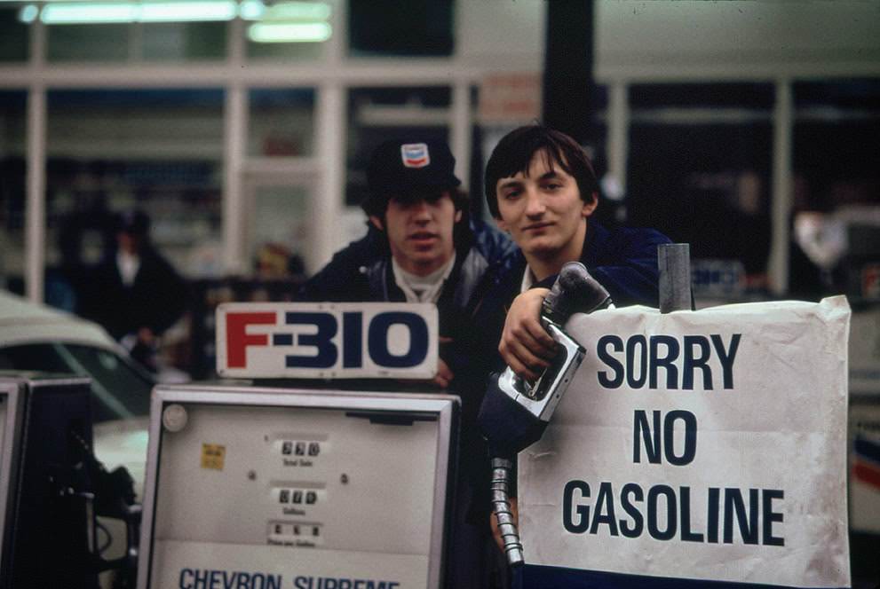 Gas station attendants peer over their "Out of Gas" sign in Portland, one day before the state's requested Saturday closure of gasoline stations, 1973.