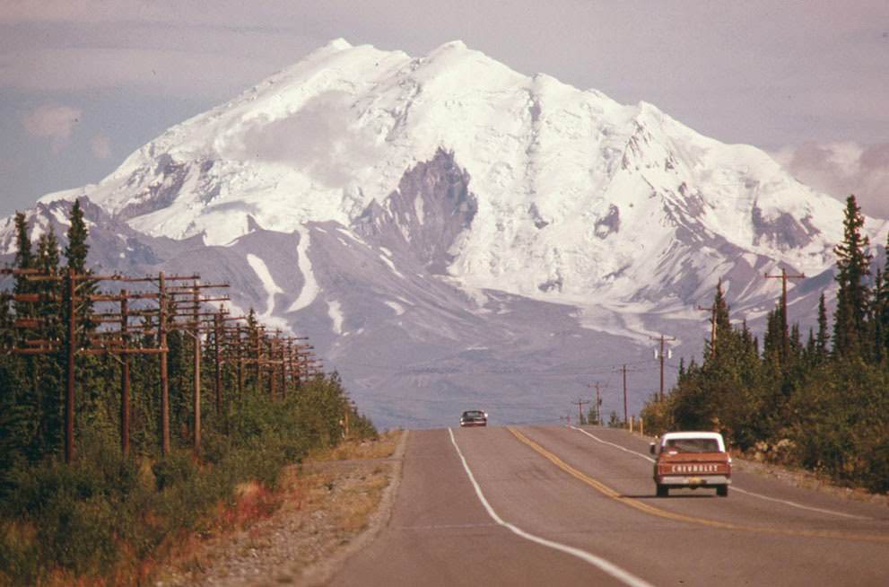 Looking east along Alaska's Glen Highway, toward Mount Drum at the intersection of the highway and the under-construction Trans-Alaska Pipeline, 1974.