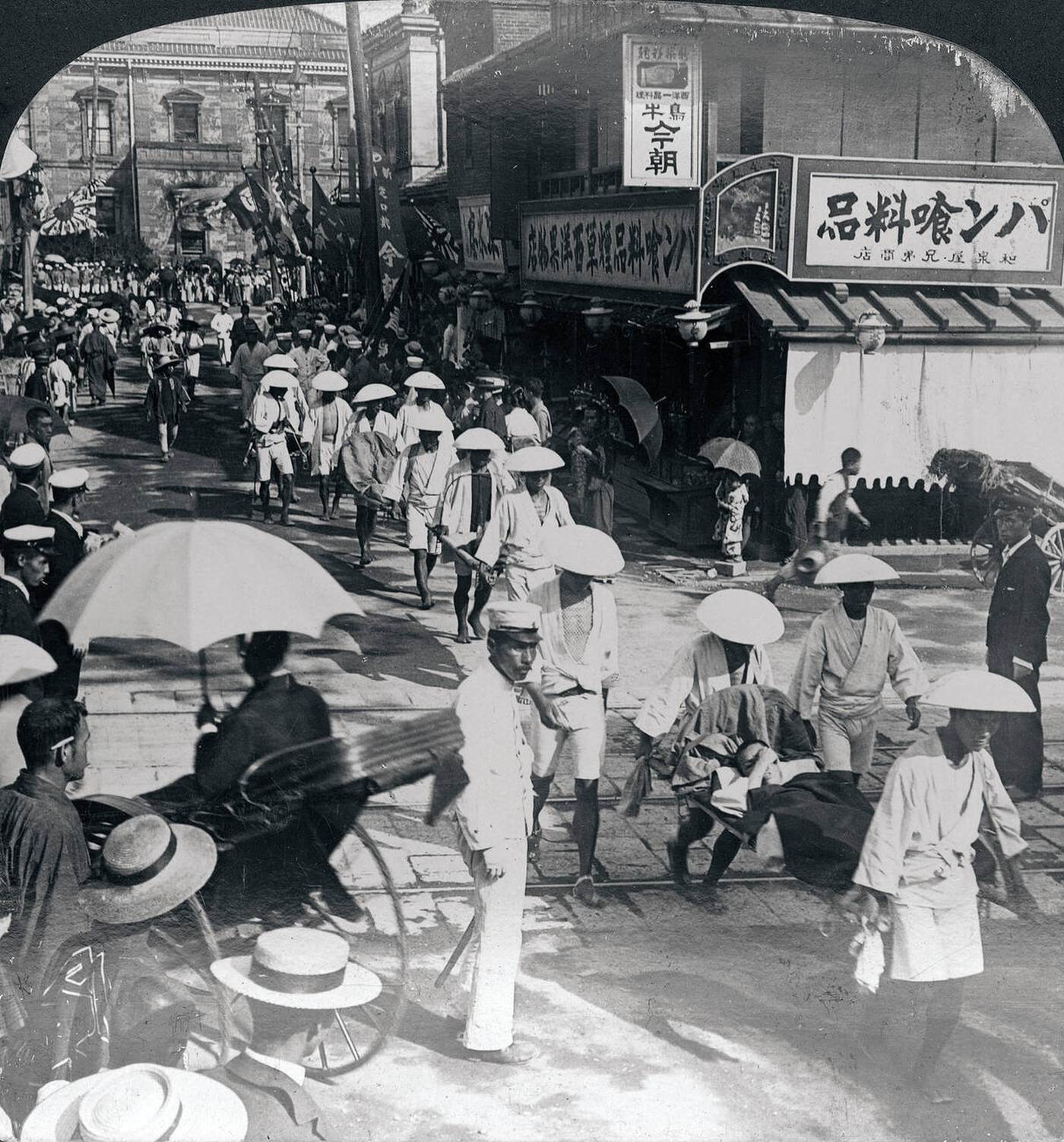 Wounded soldiers arriving from the front during the Russo-Japanese War are carried on litters from Shinbashi Station in Tokyo, 1900s.