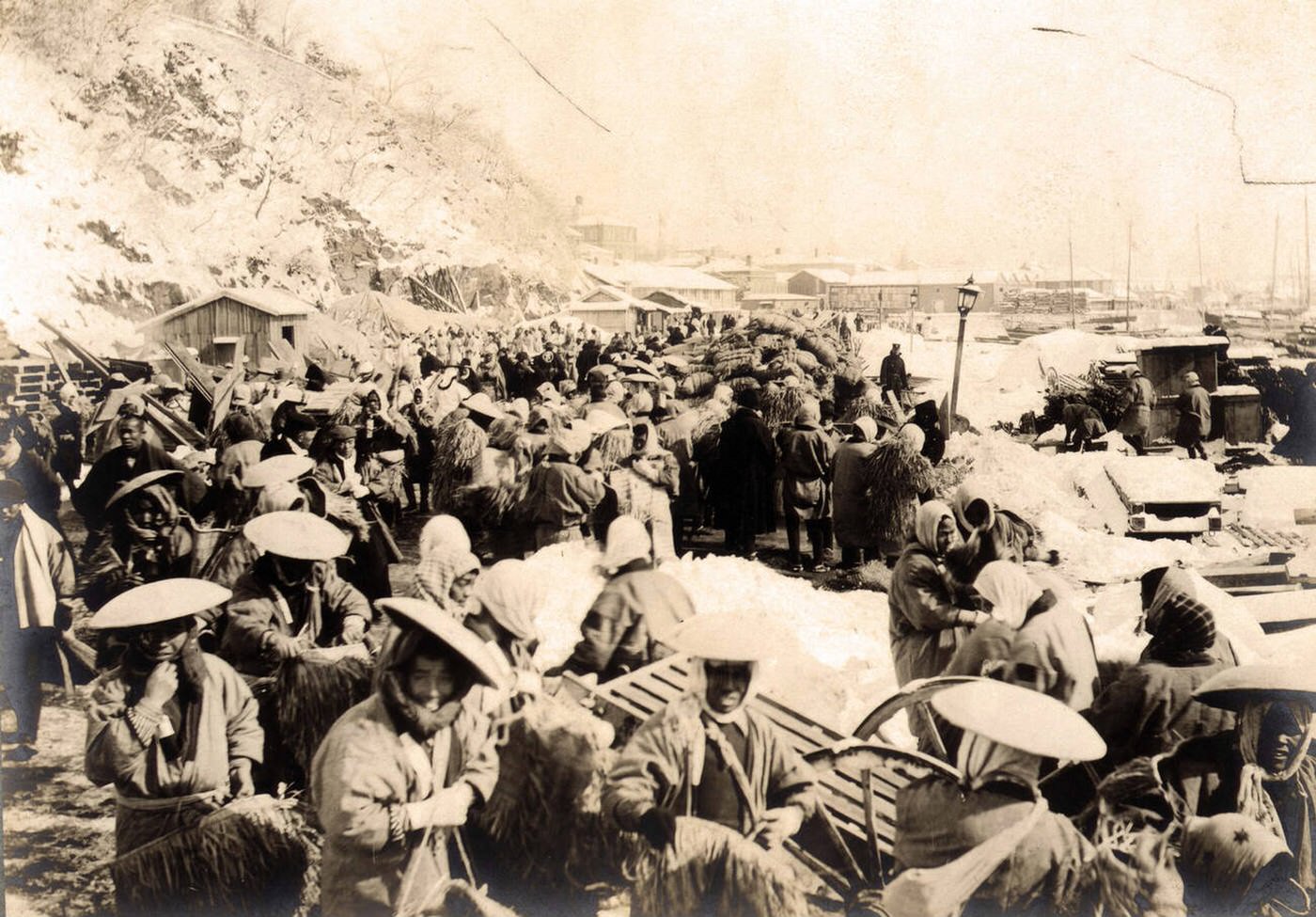 Japanese and Korean coolies removing supplies from the wharf at Chemulpo, Korea, 1904.
