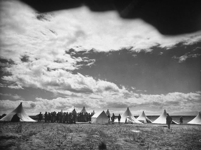 French Foreign Legion soldiers gather around newly erected tents as they set up their outpost near Homs, Syria, 1940.
