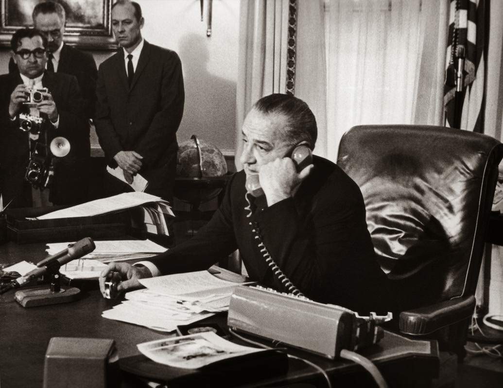 President Lyndon B. Johnson congratulates astronauts Virgil Grissom and John Young after their triple orbit of the Earth, 1965.