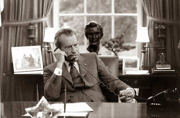President Richard Nixon on the telephone at his Oval Office desk.