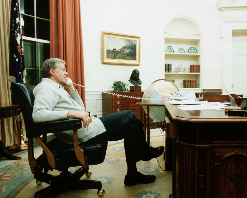 President Jimmy Carter speaks on the phone in the Oval Office in Washington, DC.