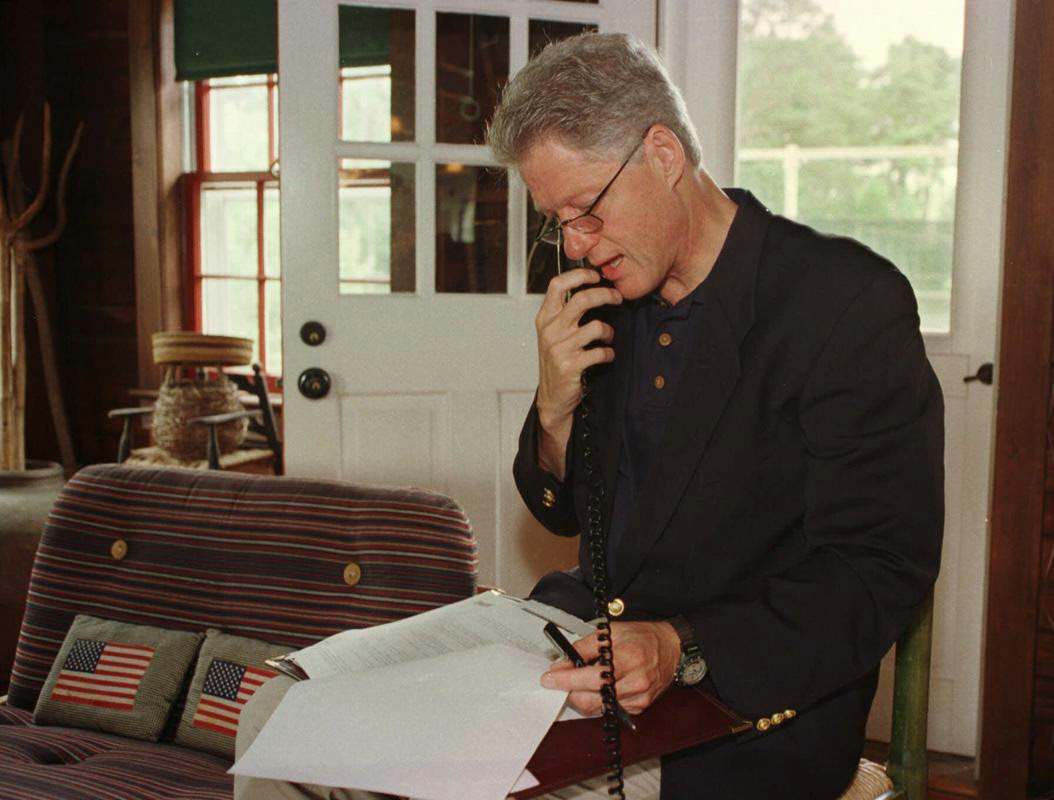 President Bill Clinton talks on the phone to Russian President Boris Yeltsin from his vacation home on Martha's Vineyard in Massachusetts, 1998.