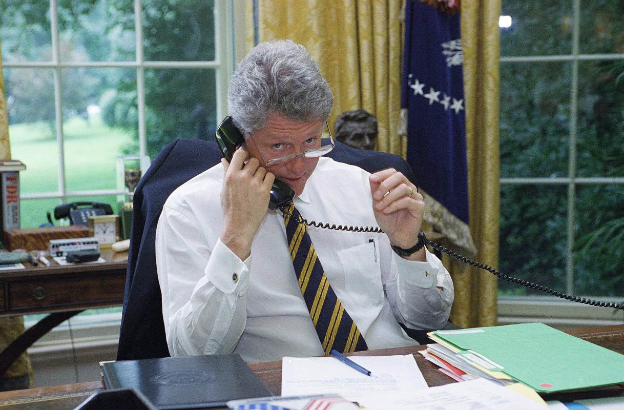 President Bill Clinton speaks via telephone from the Oval Office of the White House to an unidentified member of the House in Washington, 1994.