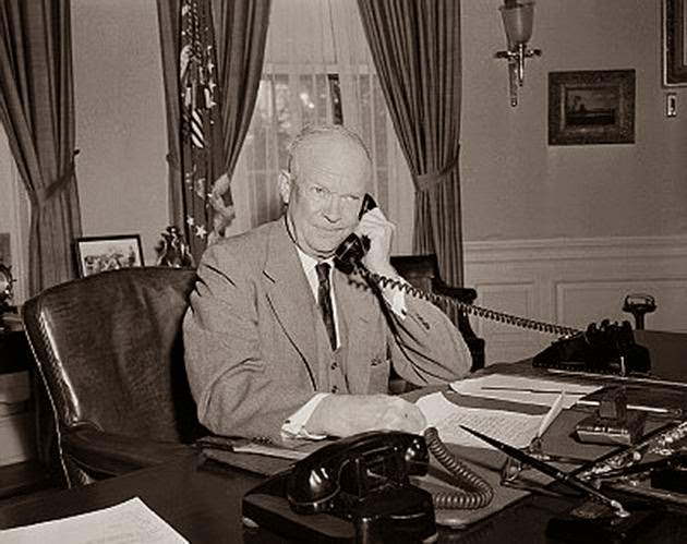 President Dwight Eisenhower conversing by phone at his desk, circa 1954.