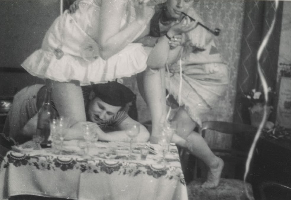 Man grabbing a woman's leg at a party.