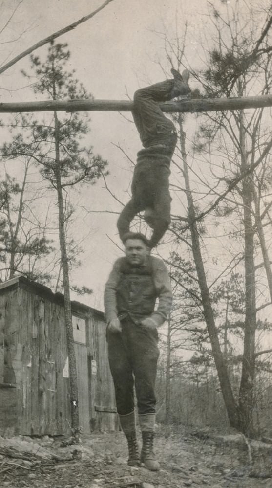 Man hanging from a pole by his feet.